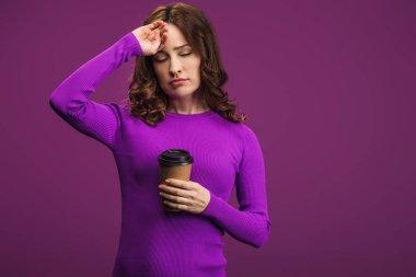 exhausted girl touching forehead while holding coffee to go on purple background clipart