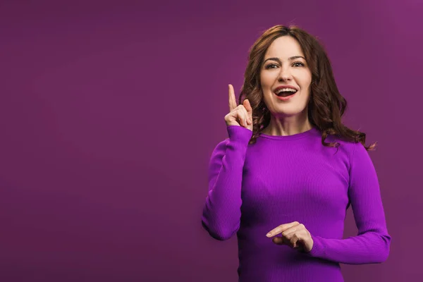 紫色の背景にアイデアジェスチャーを示す笑顔の女性 — ストック写真