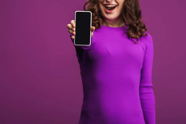 紫色の背景にスマートフォンを白い画面で見せる女性の笑顔が切り取られ — ストック写真