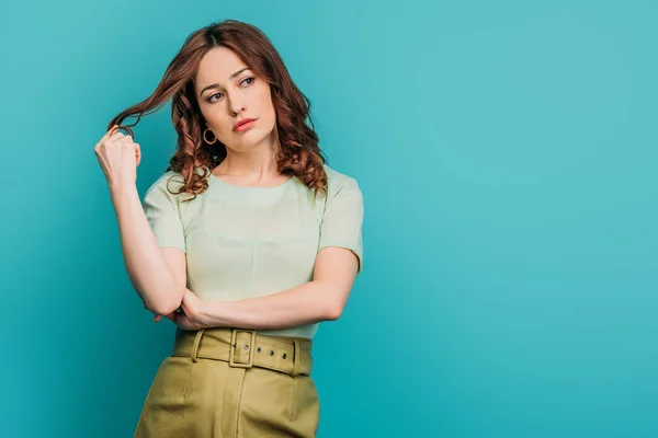 Upset Woman Looking Away Touching Hair While Standing Blue Background — 스톡 사진