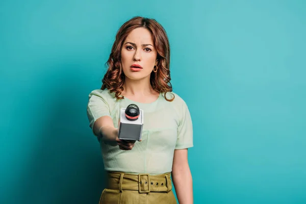 Jornalista Sério Olhando Para Câmera Enquanto Segurando Microfone Fundo Azul — Fotografia de Stock