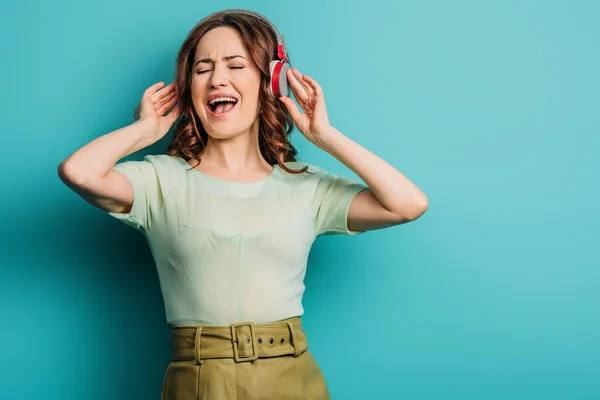 Cheerful Girl Singing Wireless Headphones Closed Eyes Blue Background — Stock Photo, Image