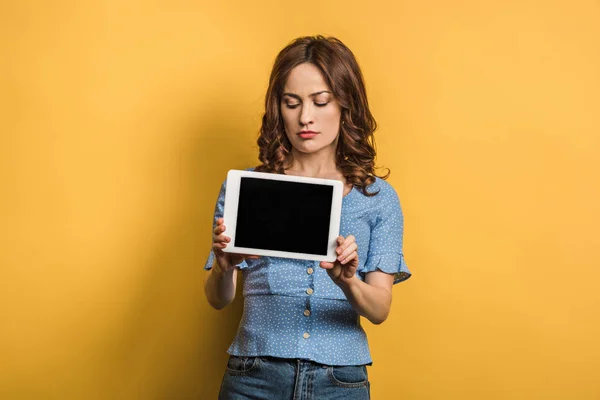 Sceptische Vrouw Toont Digitale Tablet Met Blanco Scherm Gele Achtergrond — Stockfoto