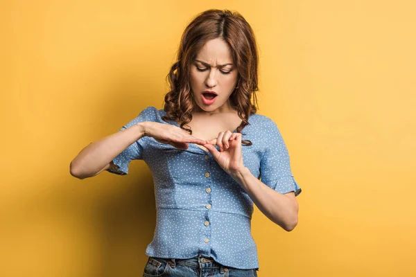 Mujer Joven Molesta Tocando Las Uñas Sobre Fondo Amarillo —  Fotos de Stock