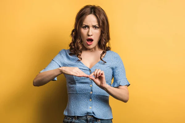 Displeased Woman Touching Nails While Looking Camera Yellow Background — 스톡 사진