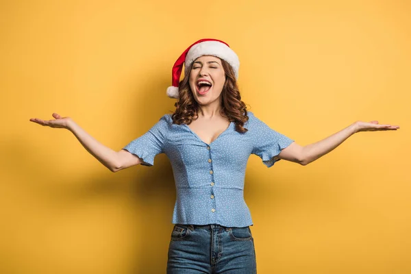 Ενθουσιασμένο Κορίτσι Καπέλο Santa Γελώντας Ανοιχτές Αγκάλες Κίτρινο Φόντο — Φωτογραφία Αρχείου