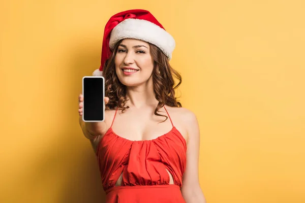 Noel Baba Şapkalı Gülümseyen Kız Sarı Arka Planda Boş Ekranlı — Stok fotoğraf