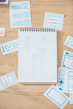 Top view of ux website wireframe sketches and planning applications on wooden table clipart