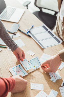 Masada çalışan web çizimleri ve mobil prototipli ux tasarımcılarının kırpılmış görünümü