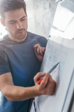 Ofisteki beyaz tahtadaki mobil uygulama için tasarım web çizimleri seçici odak noktası