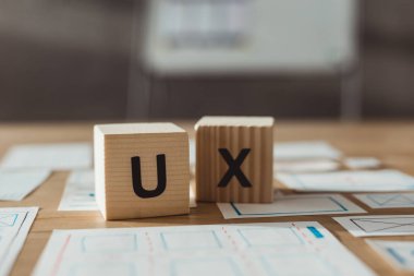 Tablo üzerinde ux harfleri ve tasarım uygulaması çizimleri olan küplerin seçici odak noktası