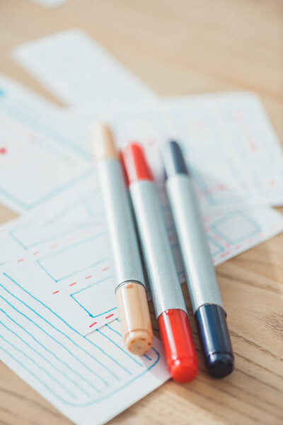 Selective focus of pens on ux sketch planning applications on wooden table