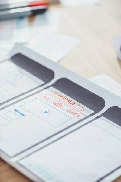 Selective focus of ui planning for mobile app on wooden table