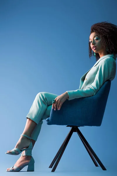 Αφροαμερικανή Γυναίκα Κάθεται Στην Πολυθρόνα Μπλε Φόντο — Φωτογραφία Αρχείου