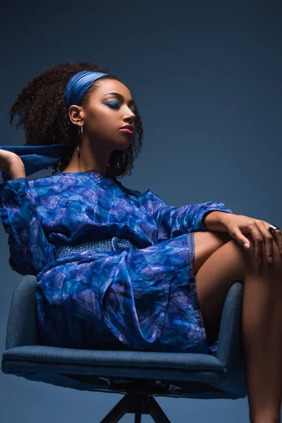 Ελκυστική Αφροαμερικανή Γυναίκα Κλειστά Μάτια Κάθεται Πολυθρόνα Απομονωμένη Στο Μπλε — Φωτογραφία Αρχείου