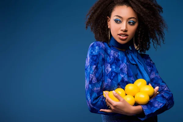 有魅力的非洲女人 拿着用蓝色隔开的柠檬 — 图库照片