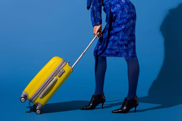 青い背景に旅行バッグを持っているアフリカ系アメリカ人女性のクロップドビュー — ストック写真