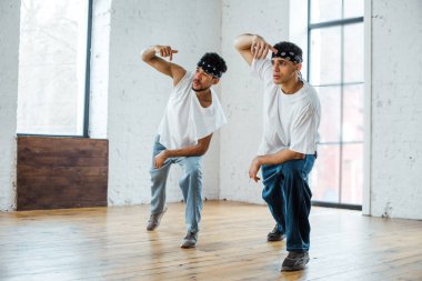 Hip-hop dansı yaparken saç bantlı genç çok kültürlü dansçılar