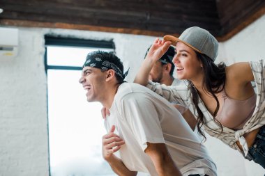 selective focus of cheerful multicultural dancers posing in dance studio 