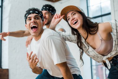 selective focus of cheerful multicultural dancers laughing in dance studio 
