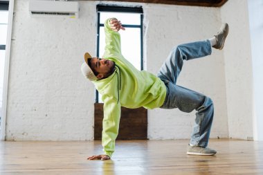 stylish african american man breakdancing in dance studio  clipart