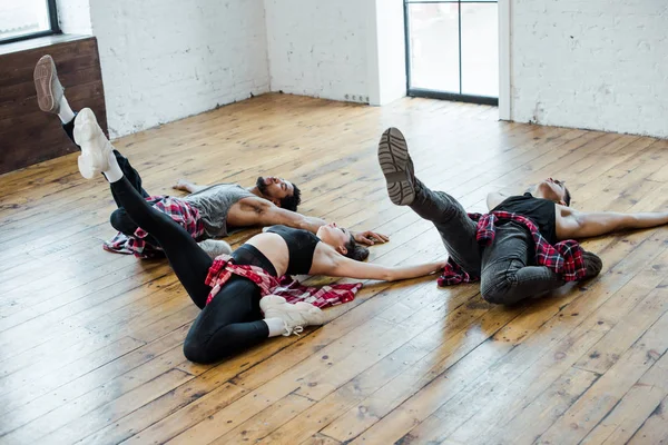 Πολυπολιτισμικοί Άνδρες Και Ελκυστική Γυναίκα Ξαπλωμένη Στο Πάτωμα Ενώ Χορεύουν — Φωτογραφία Αρχείου