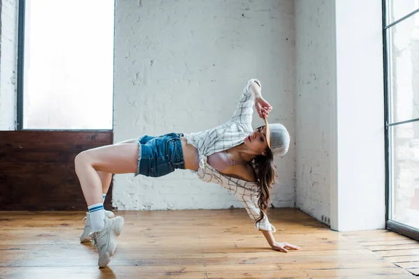 Ελκυστική Κοπέλα Που Αγγίζει Καπέλο Ενώ Χορεύει Hip Hop Στούντιο — Φωτογραφία Αρχείου