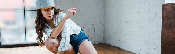 панорамный снимок привлекательной танцовщицы, позирующей в танцевальной студии
 