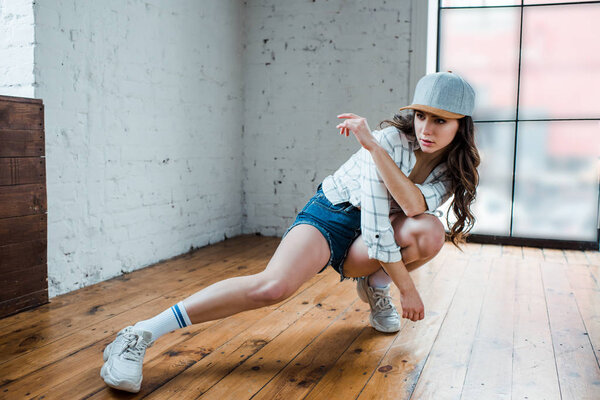 attractive dancer with crossed arms dancing hip-hop in dance studio 