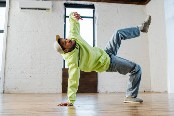 stylish african american man breakdancing in dance studio 