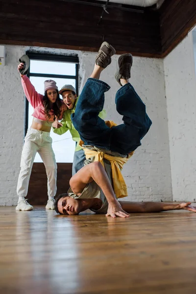 在兴奋的多文化舞蹈家身边跳霹雳的英俊男人的选择性焦点 — 图库照片