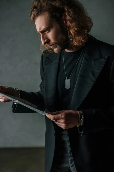 Tenso Hombre Negocios Moda Traje Negro Leyendo Periódico Oscuridad — Foto de Stock