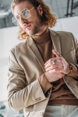 Gözlüklü şık moda işadamı ofisinden dışarı bakıyor.