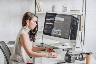 side view of attractive art editor working near computer monitors  clipart