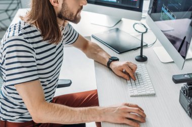 Bilgisayar klavyesi kullanan sanat editörünün kırpılmış görünümü 
