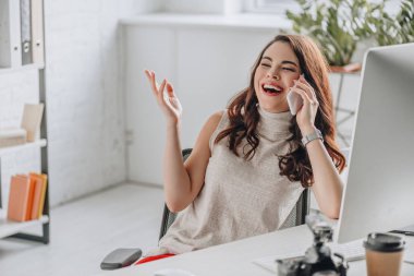 Akıllı telefondan konuşan mutlu sanat editörünün seçici odağı 