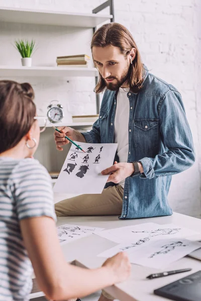 Enfoque Selectivo Del Ilustrador Mirando Mujer Mostrando Dibujos Animados — Foto de Stock