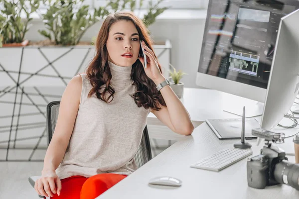 Attraktive Redakteurin Spricht Auf Smartphone Der Nähe Von Computermonitoren — Stockfoto