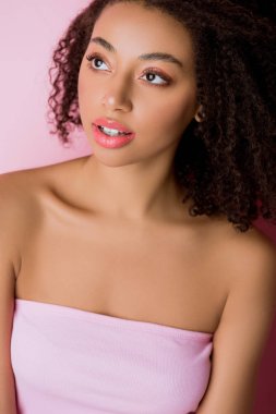 Çekici bir Afrikalı Amerikalı kızın portresi, pembe üzerine izole edilmiş.