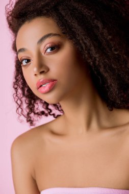 Pembe üzerine izole edilmiş, kameraya bakan Afrikalı Amerikalı kızın portresi.