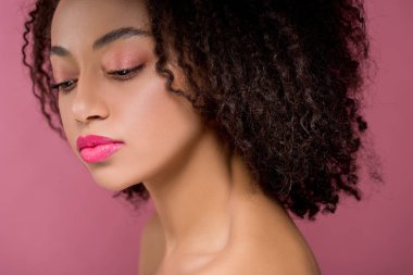 Güzel, düşünceli bir Afrikalı Amerikalı kızın portresi, pembe üzerine izole edilmiş.