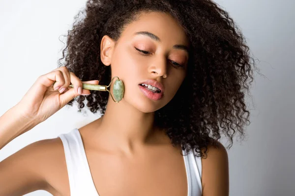Hermosa Chica Afroamericana Utilizando Rodillo Facial Piedra Aislado Gris — Foto de Stock