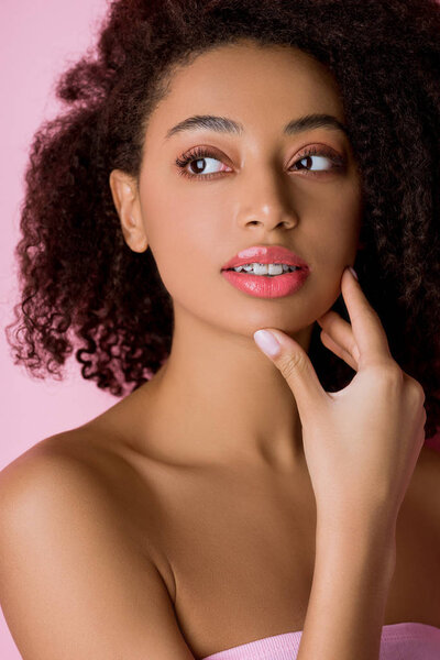 attractive thoughtful african american girl with dental braces, isolated on pink