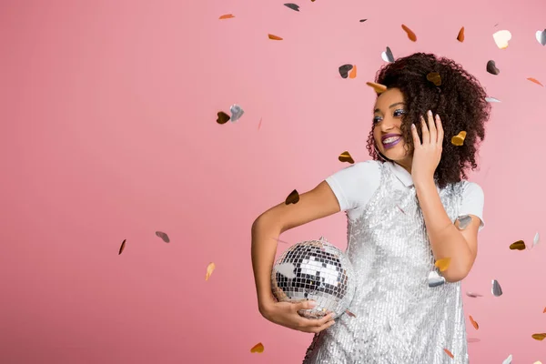 有魅力的快乐的非洲裔美国女孩 身穿紧握迪斯科舞会的紧身衣 与五彩纸屑隔离在粉红上 — 图库照片
