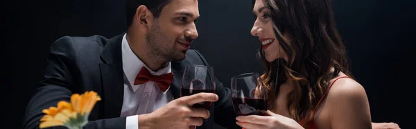 全景拍摄的优雅夫妻 戴着酒杯 面带微笑 彼此隔离在黑暗中 — 图库照片
