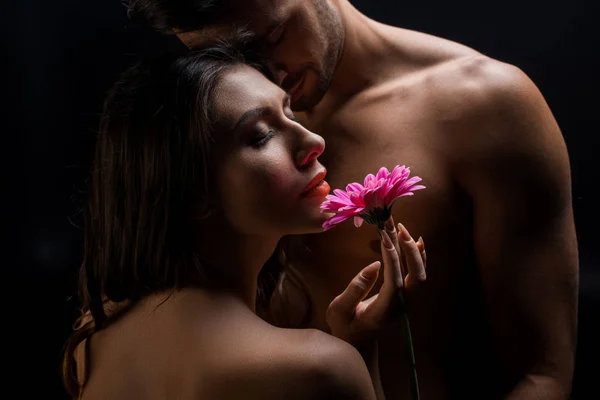 Hermosa Mujer Sosteniendo Gerbera Por Guapo Sin Camisa Hombre Aislado —  Fotos de Stock