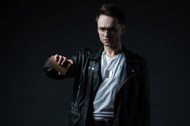 Keyifsiz, stil sahibi, motorcu ceketli, siyah üzerine izole olmak için kahve dolduran vahşi adam.