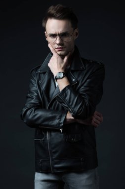 Gergin, düşünceli, stil sahibi, motorcu ceketli, siyah giyimli vahşi adam.