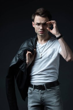 Motosikletli ceketli, gözlüklü, siyah gözlükle poz veren şık vahşi bir adam.