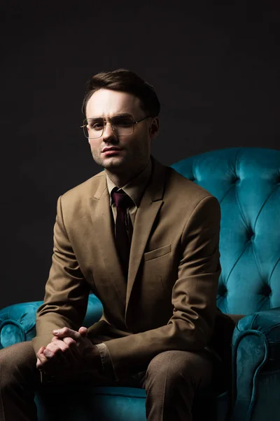 Eleganter Mann Mit Beiger Anzugbrille Sitzt Mit Geballten Händen Blauen — Stockfoto